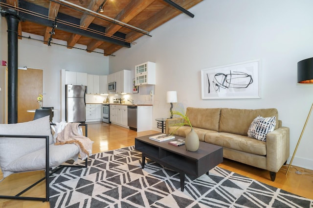 150 E Main St Unit 405, Columbus, OH 43215 - living room with a wooden ceiling with exposed beams, a high ceiling, and light wood-style floors