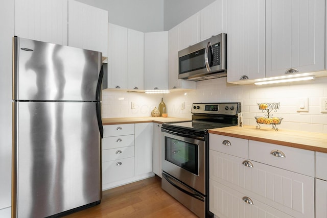 150 E Main St Unit 405, Columbus, OH 43215 - kitchen featuring appliances with stainless steel finishes, butcher block countertops, light wood-style flooring, backsplash, and white cabinets