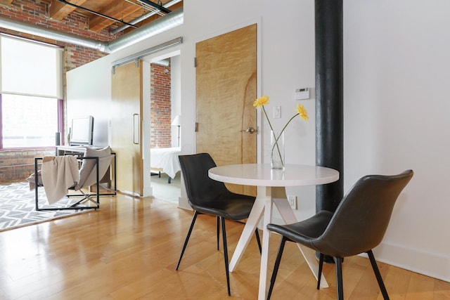 150 E Main St Unit 405, Columbus, OH 43215 - dining space with brick wall, a high ceiling, and light wood-style floors