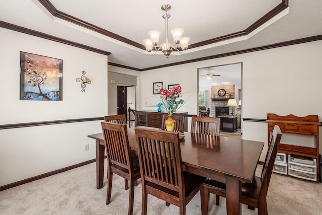 2461 Abbey Knoll Dr, Lewis Center, OH 43035 - dining room with a raised ceiling, a chandelier, light colored carpet, a brick fireplace, and a ceiling fan