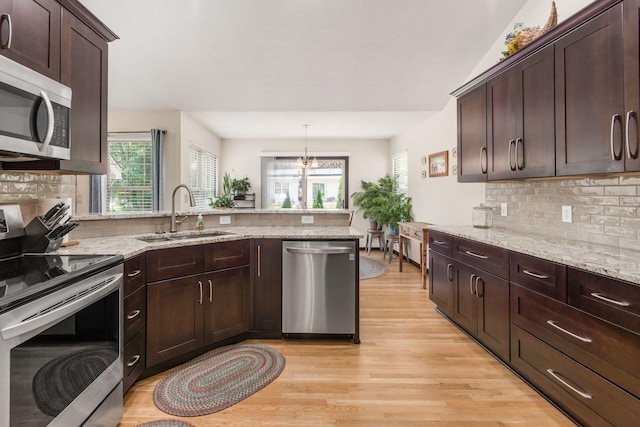 2461 Abbey Knoll Dr, Lewis Center, OH 43035 - kitchen with appliances with stainless steel finishes, a peninsula, light wood-type flooring, dark brown cabinets, and decorative backsplash