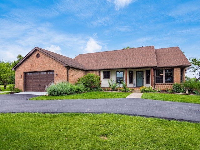 8120 Morgan Rd, West Jefferson, OH 43162 - view of front of house with brick siding, an attached garage, a porch, and a front yard