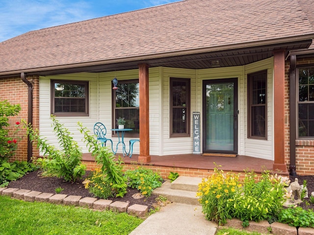 8120 Morgan Rd, West Jefferson, OH 43162 - view of exterior entry with a porch, a shingled roof, and brick siding