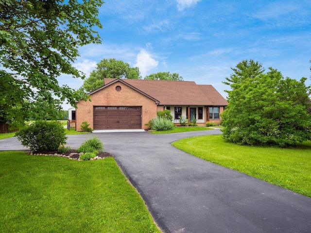 8120 Morgan Rd, West Jefferson, OH 43162 - ranch-style home with a garage, brick siding, driveway, and a front lawn