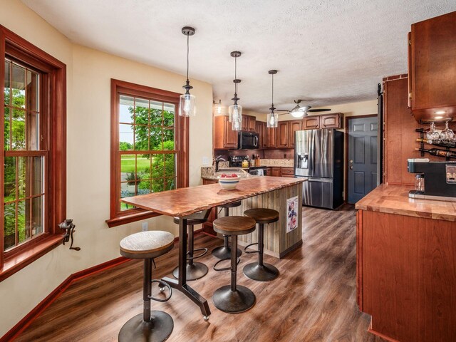 8120 Morgan Rd, West Jefferson, OH 43162 - kitchen featuring stainless steel appliances, a peninsula, dark wood finished floors, hanging light fixtures, and a textured ceiling