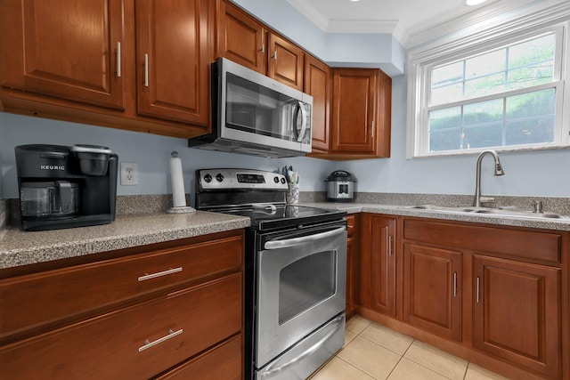 1365 Bluff Ave Unit B, Columbus, OH 43212 - kitchen featuring stainless steel appliances, brown cabinetry, ornamental molding, and light tile patterned floors
