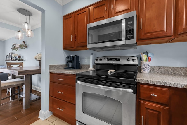 1365 Bluff Ave Unit B, Columbus, OH 43212 - kitchen with stainless steel appliances, crown molding, light countertops, hanging light fixtures, and brown cabinets
