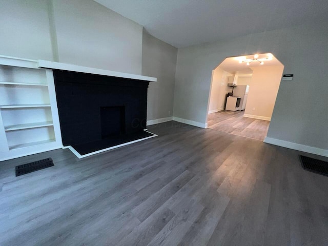 691-693 N Dawson Ave, Columbus, OH 43219 - unfurnished living room with wood finished floors, arched walkways, and built in shelves
