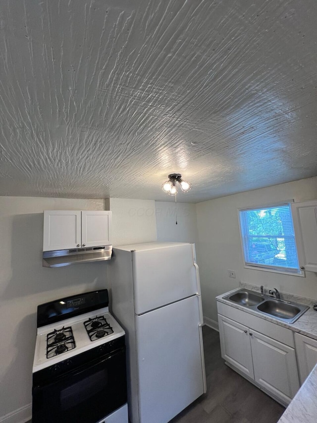 691-693 N Dawson Ave, Columbus, OH 43219 - kitchen featuring gas stove, under cabinet range hood, freestanding refrigerator, white cabinetry, and light countertops