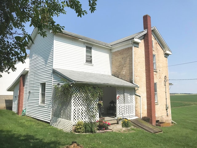 8023 County Road 30, Somerset, OH 43783 - back of house with a lawn, a chimney, and brick siding