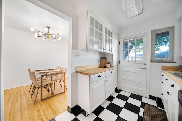 1809 NW Ct Unit C, Columbus, OH 43212 - kitchen featuring light flooring, glass insert cabinets, white cabinetry, and a chandelier