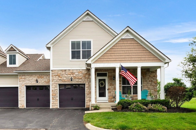 4724 Trademark Trl, Hilliard, OH 43026 - view of front of property with stone siding, driveway, a front lawn, and a porch