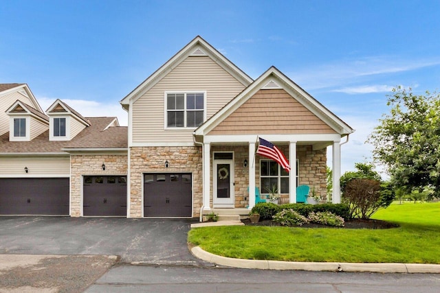 4724 Trademark Trl, Hilliard, OH 43026 - view of front facade featuring stone siding, driveway, a front yard, covered porch, and an attached garage