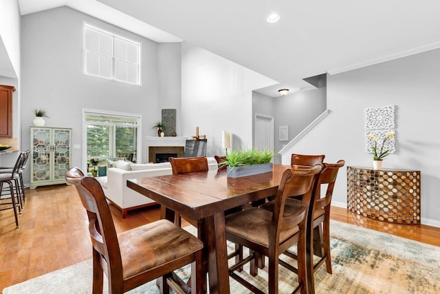 4724 Trademark Trl, Hilliard, OH 43026 - dining space featuring a fireplace, light wood-style flooring, recessed lighting, and a towering ceiling