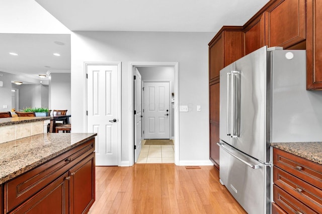 4724 Trademark Trl, Hilliard, OH 43026 - kitchen featuring high end fridge, light wood finished floors, light stone countertops, baseboards, and crown molding