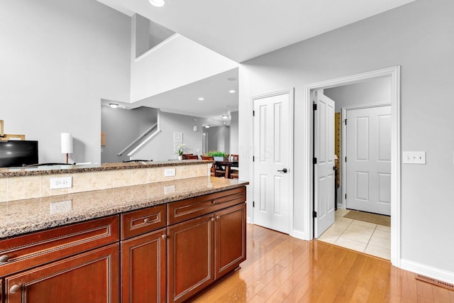 4724 Trademark Trl, Hilliard, OH 43026 - kitchen featuring light stone countertops, light wood-type flooring, and baseboards