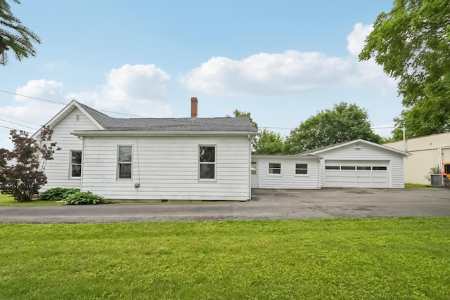 45 S Main St, New Holland, OH 43145 - view of property exterior with a detached garage, a chimney, a yard, cooling unit, and an outbuilding