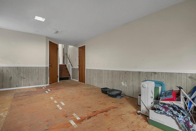 5990 Roselawn Ave, Columbus, OH 43232 - empty room featuring a wainscoted wall, stairway, and wooden walls