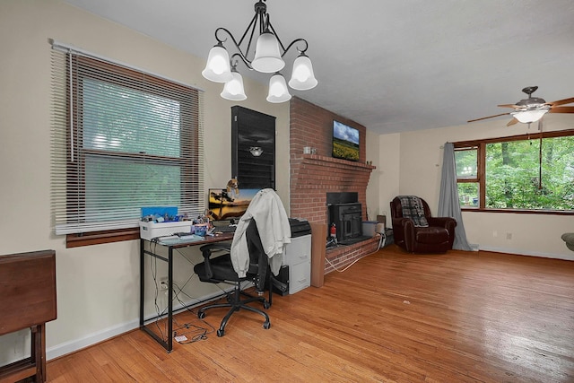 5990 Roselawn Ave, Columbus, OH 43232 - home office with wood finished floors, a ceiling fan, baseboards, a chandelier, and a fireplace