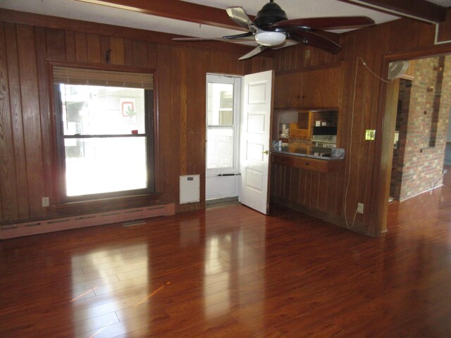 470 Beacon Rd, Newark, OH 43055 - unfurnished living room featuring wood walls, beam ceiling, ceiling fan, dark wood-type flooring, and baseboard heating