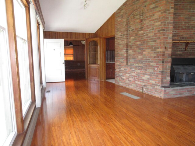 470 Beacon Rd, Newark, OH 43055 - unfurnished living room with wood-type flooring, vaulted ceiling, and a wood stove