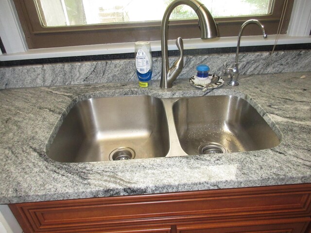 470 Beacon Rd, Newark, OH 43055 - kitchen view of a sink, reddish brown cabinets, and light stone counters