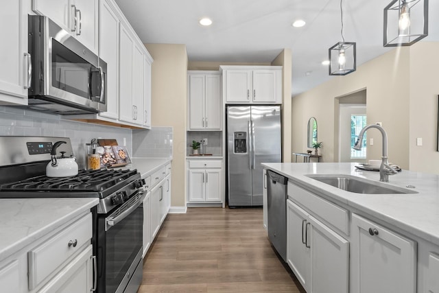 5508 Camlin Pl W Unit 48, Westerville, OH 43081 - kitchen featuring appliances with stainless steel finishes, wood finished floors, white cabinetry, decorative backsplash, and recessed lighting