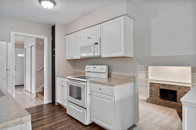 2220 Surreygate Dr, Columbus, OH 43235 - kitchen with white appliances, white cabinetry, light countertops, dark wood-style floors, and a textured ceiling