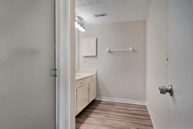 2220 Surreygate Dr, Columbus, OH 43235 - bathroom with vanity, wood finished floors, a textured ceiling, and a shower with door