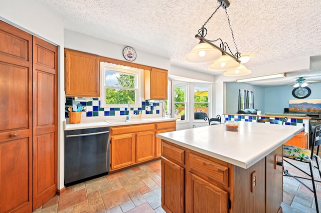5138 Eastbend Dr, Canal Winchester, OH 43110 - kitchen featuring dishwashing machine, light countertops, a textured ceiling, decorative backsplash, and a kitchen island