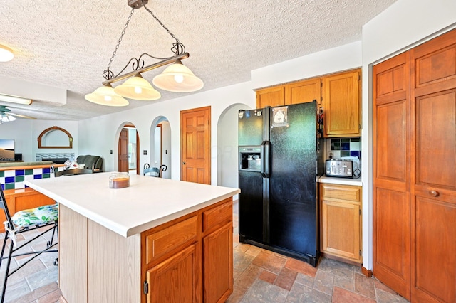 5138 Eastbend Dr, Canal Winchester, OH 43110 - kitchen featuring black fridge, a textured ceiling, arched walkways, light countertops, and open floor plan