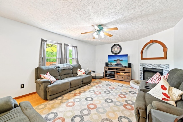 5138 Eastbend Dr, Canal Winchester, OH 43110 - living area featuring wood finished floors, a ceiling fan, a textured ceiling, and a fireplace