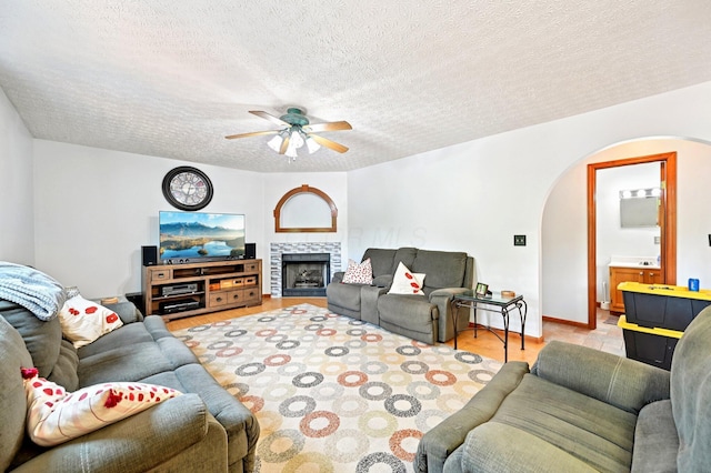 5138 Eastbend Dr, Canal Winchester, OH 43110 - living room with arched walkways, ceiling fan, a textured ceiling, and a fireplace