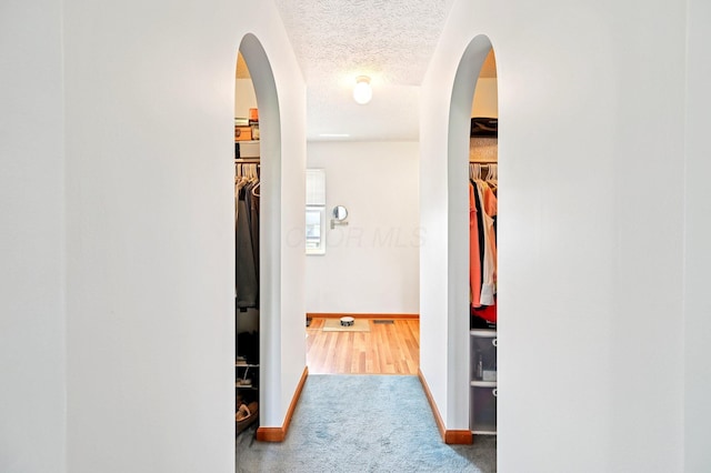 5138 Eastbend Dr, Canal Winchester, OH 43110 - corridor featuring arched walkways, a textured ceiling, and carpet flooring