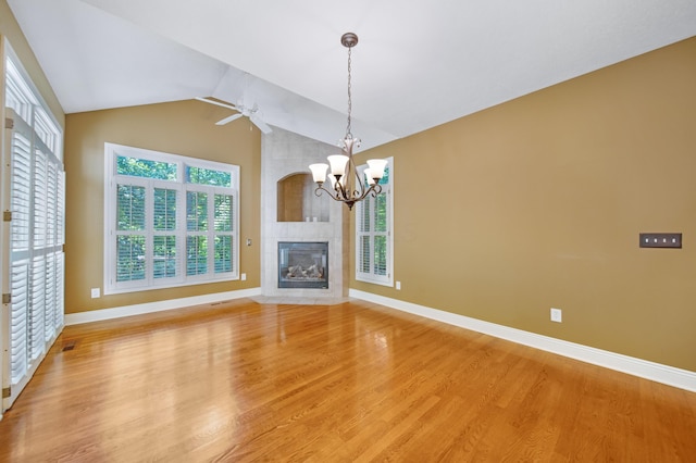 7788 Boylston Ct, Dublin, OH 43016 - unfurnished living room featuring light wood-style floors, a chandelier, lofted ceiling, ceiling fan, and a tile fireplace