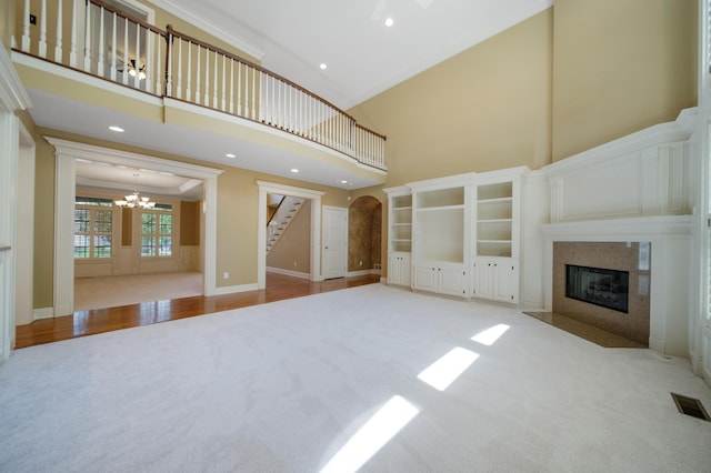 7788 Boylston Ct, Dublin, OH 43016 - unfurnished living room with crown molding, carpet, a chandelier, a high end fireplace, and a high ceiling