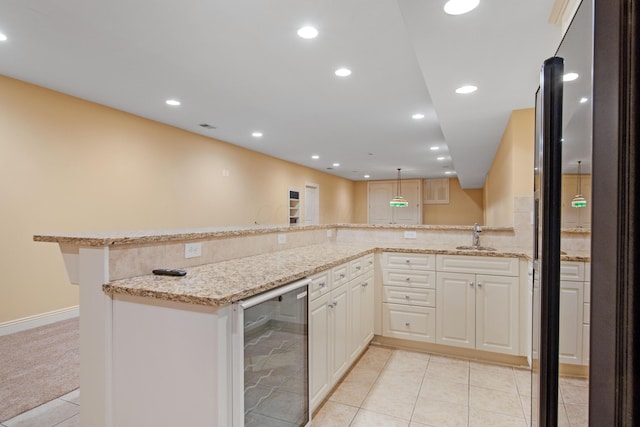 7788 Boylston Ct, Dublin, OH 43016 - kitchen featuring beverage cooler, light stone counters, light tile patterned floors, recessed lighting, and a peninsula