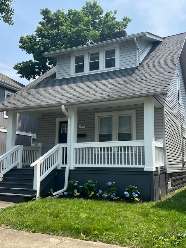 1476 N 6th St, Columbus, OH 43201 - bungalow-style house featuring roof with shingles, a porch, a chimney, and a front yard