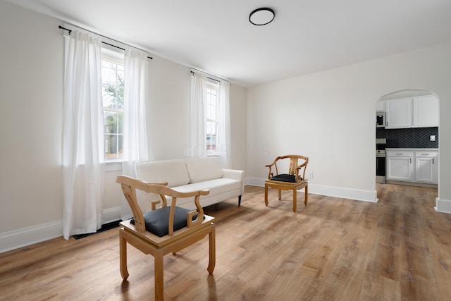 490 E Mithoff St, Columbus, OH 43206 - sitting room featuring arched walkways, light wood-style floors, and baseboards