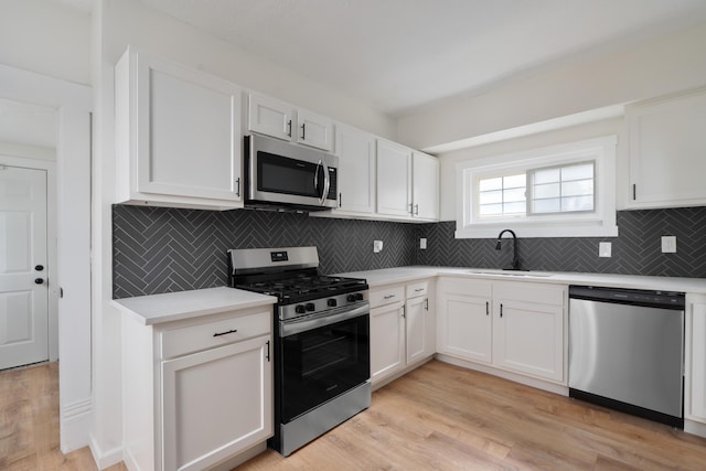 490 E Mithoff St, Columbus, OH 43206 - kitchen with stainless steel appliances, a sink, light countertops, and white cabinets
