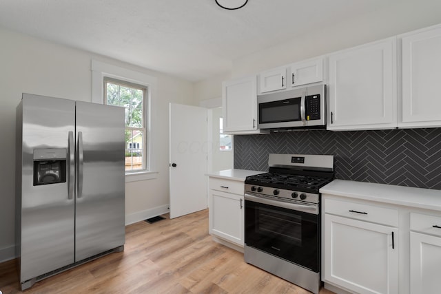 490 E Mithoff St, Columbus, OH 43206 - kitchen with stainless steel appliances, decorative backsplash, white cabinets, and light countertops