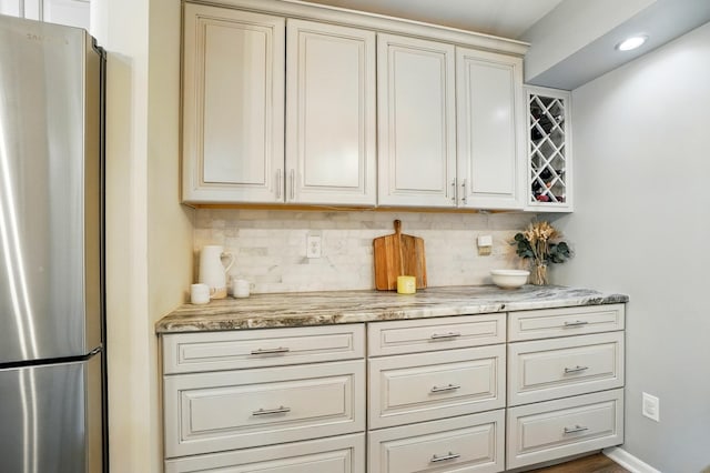 6235 Hampton Green Pl Unit 5B, Dublin, OH 43016 - kitchen with freestanding refrigerator, backsplash, and light stone counters