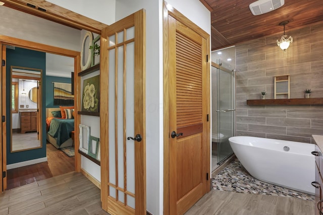1859 State Route 257 N, Ostrander, OH 43061 - full bathroom with wood finished floors, a shower stall, a freestanding bath, tile walls, and wood ceiling