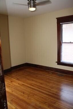 65 Warren St Unit 1/2, Columbus, OH 43215 - spare room featuring wood finished floors, baseboards, and a ceiling fan
