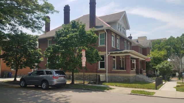 65 Warren St Unit 1/2, Columbus, OH 43215 - view of property exterior featuring a fenced front yard, brick siding, and a chimney