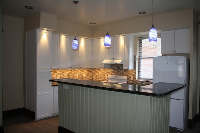 65 Warren St Unit 1/2, Columbus, OH 43215 - kitchen featuring under cabinet range hood, stove, decorative backsplash, white cabinetry, and dark countertops