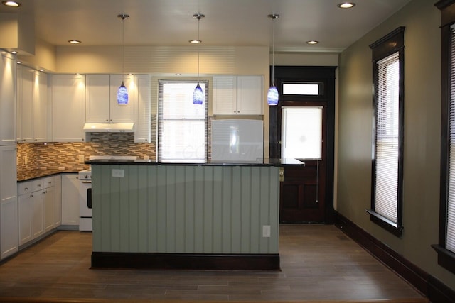 65 Warren St Unit 1/2, Columbus, OH 43215 - kitchen featuring under cabinet range hood, refrigerator, dark countertops, tasteful backsplash, and dark wood-style flooring