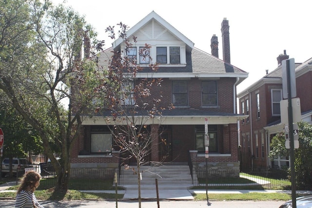 65 Warren St Unit 1/2, Columbus, OH 43215 - view of front of property featuring brick siding, covered porch, and a chimney