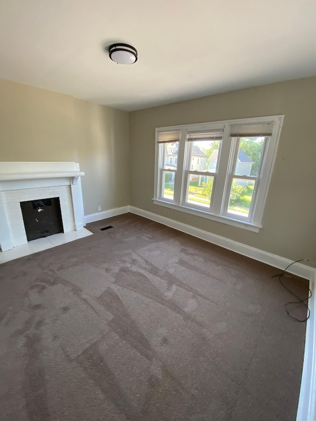 384 E 17th Ave, Columbus, OH 43201 - unfurnished living room with healthy amount of natural light, baseboards, dark carpet, and a fireplace with flush hearth