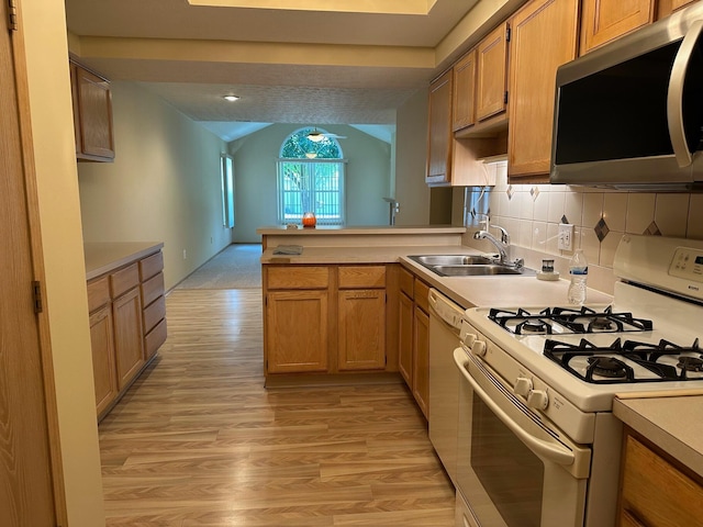 2328 Willowside Ln, Grove City, OH 43123 - kitchen featuring white appliances, a peninsula, vaulted ceiling, light countertops, and light wood finished floors